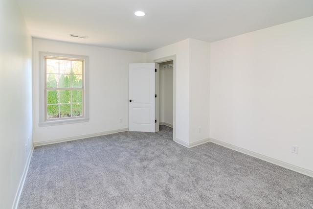 unfurnished room featuring light carpet