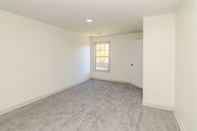 unfurnished room featuring light carpet