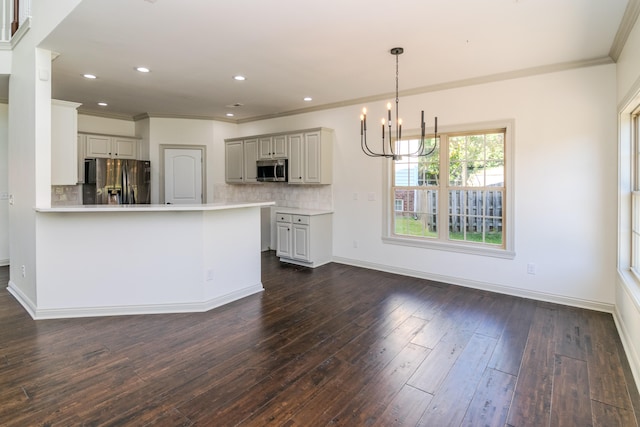 kitchen with kitchen peninsula, decorative backsplash, hanging light fixtures, dark hardwood / wood-style flooring, and stainless steel appliances