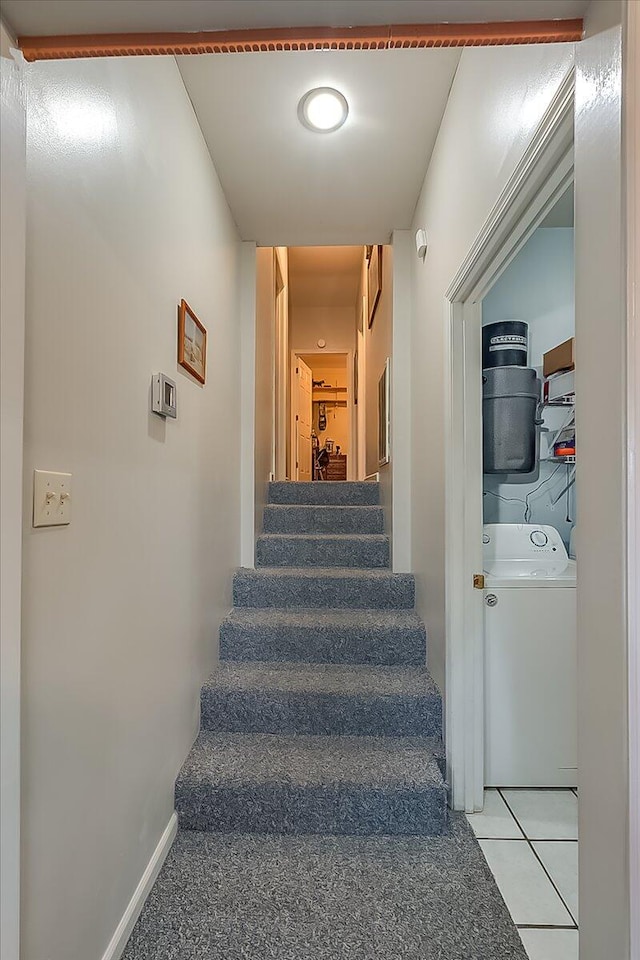 staircase featuring tile patterned floors and washer / clothes dryer