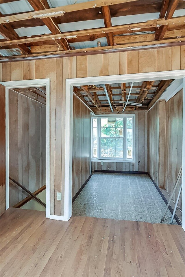 miscellaneous room featuring light hardwood / wood-style flooring and wooden walls