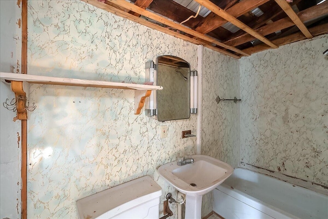 bathroom with sink, a tub, and toilet