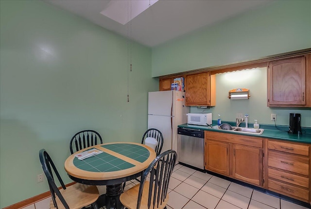 kitchen with sink, light tile patterned floors, and white appliances