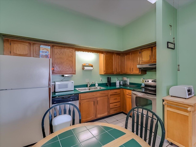 kitchen featuring white appliances, light tile patterned floors, and sink