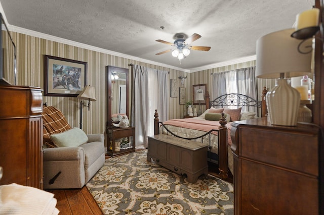 bedroom with hardwood / wood-style flooring, ornamental molding, and a textured ceiling