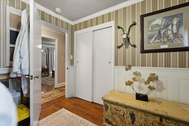 foyer with crown molding, a textured ceiling, and hardwood / wood-style floors