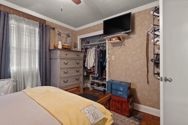 bedroom with hardwood / wood-style floors, crown molding, a closet, and ceiling fan