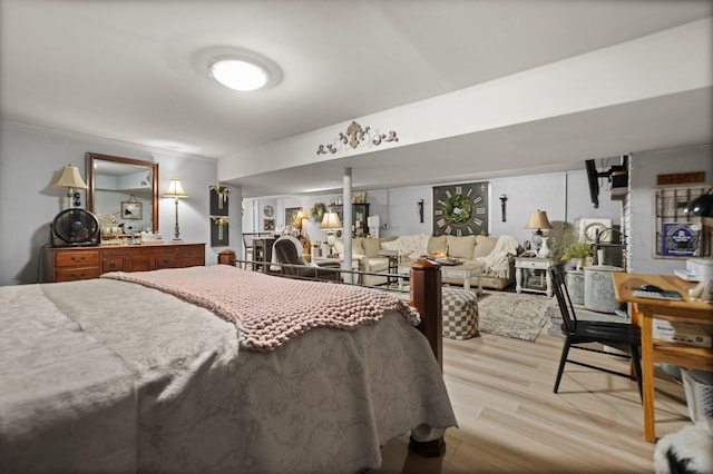 bedroom featuring ornamental molding and light hardwood / wood-style flooring