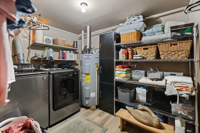 washroom with light hardwood / wood-style flooring, electric water heater, and independent washer and dryer