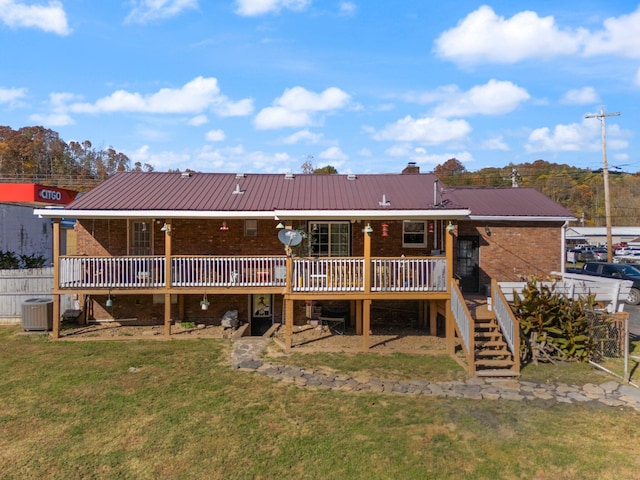 back of property featuring central AC, a wooden deck, and a lawn