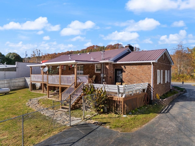 back of property with a yard and a wooden deck