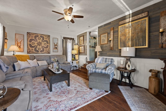 living room featuring wooden walls, crown molding, dark hardwood / wood-style floors, and ceiling fan