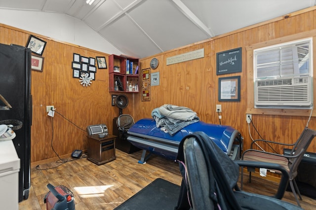 bedroom featuring wood walls, cooling unit, vaulted ceiling, and light wood-type flooring