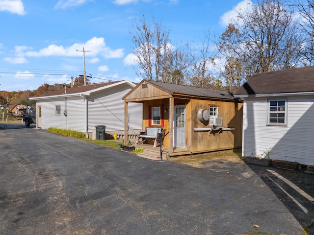 view of front of home with cooling unit and an outbuilding