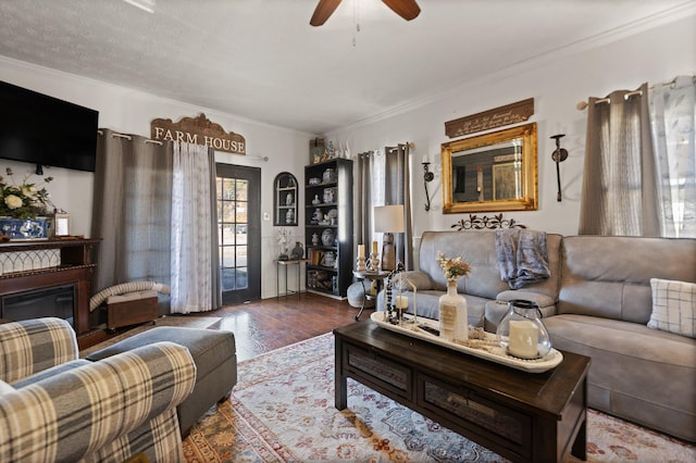 living room with crown molding, dark hardwood / wood-style floors, a textured ceiling, and ceiling fan