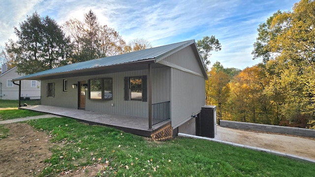 view of property exterior with covered porch and a lawn