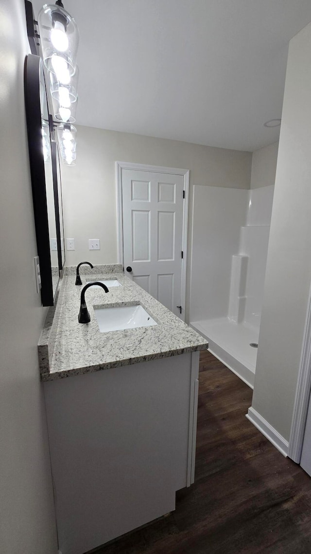 bathroom with vanity, a shower, and hardwood / wood-style flooring