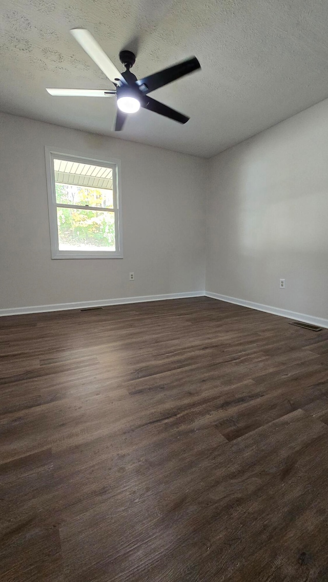 unfurnished room featuring dark wood-type flooring, a textured ceiling, and ceiling fan