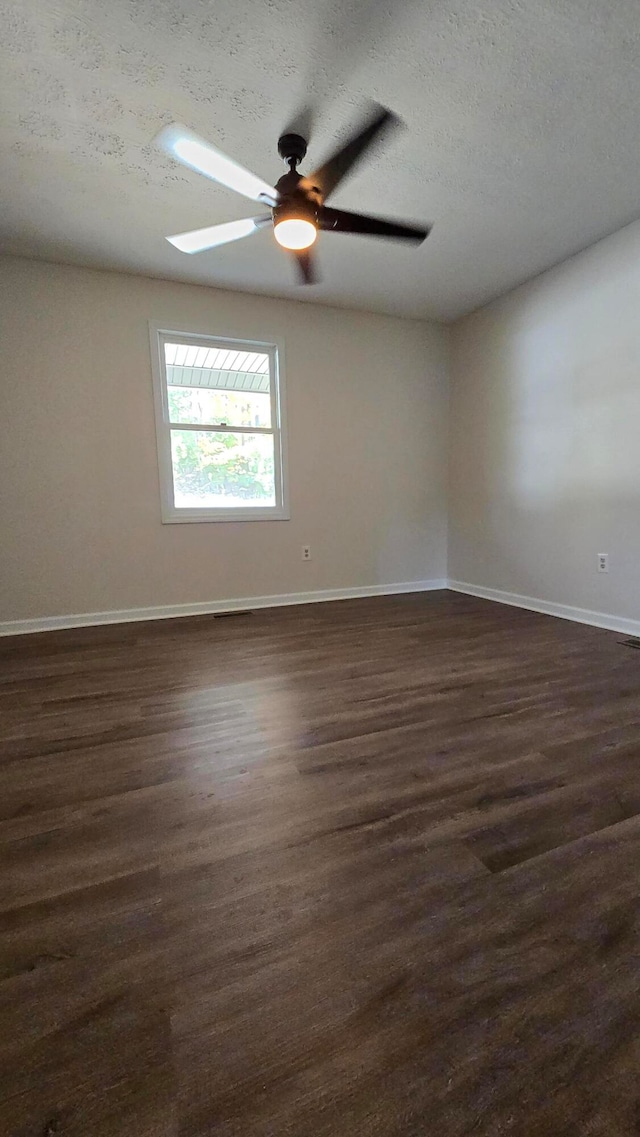 empty room with ceiling fan, a textured ceiling, and dark hardwood / wood-style flooring