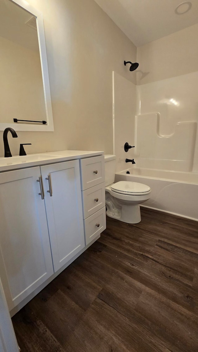 full bathroom with vanity, hardwood / wood-style flooring, toilet, and  shower combination