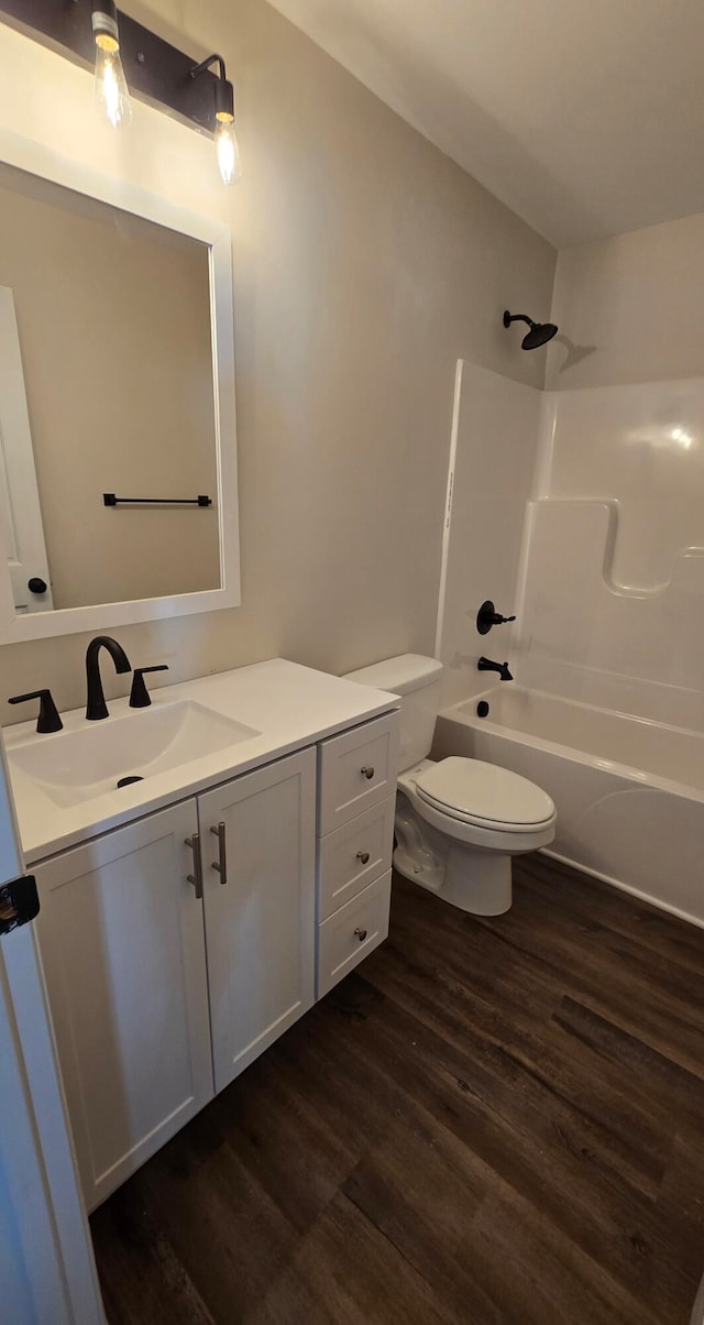 full bathroom featuring vanity, hardwood / wood-style floors, toilet, and shower / bathtub combination