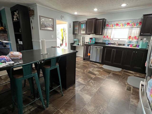 kitchen with a textured ceiling, dishwasher, decorative backsplash, and ornamental molding