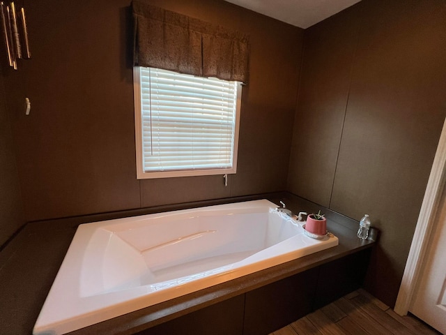 bathroom with hardwood / wood-style flooring and a tub