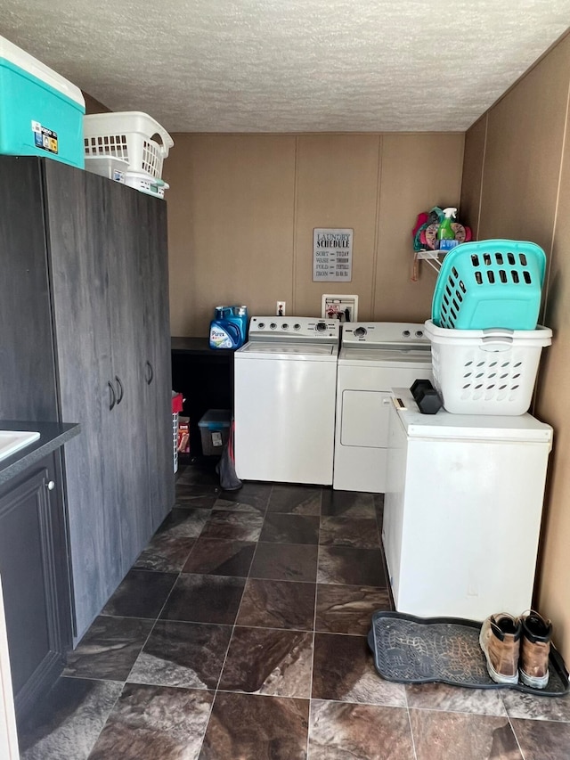 laundry room with washer and clothes dryer and a textured ceiling