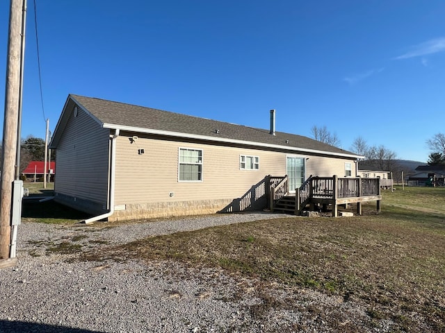 back of house featuring a yard and a deck