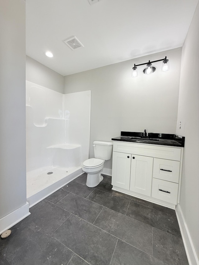 bathroom with a shower, vanity, and toilet