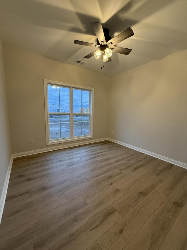 spare room featuring wood-type flooring, a water view, and ceiling fan