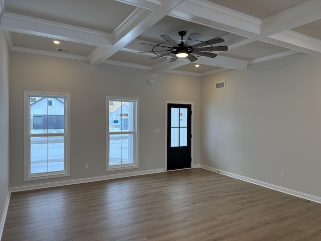 spare room with beam ceiling, a wealth of natural light, and coffered ceiling