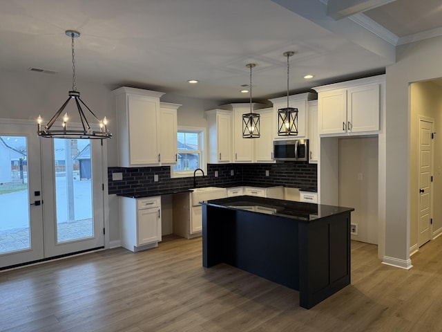 kitchen featuring pendant lighting, a center island, and white cabinetry