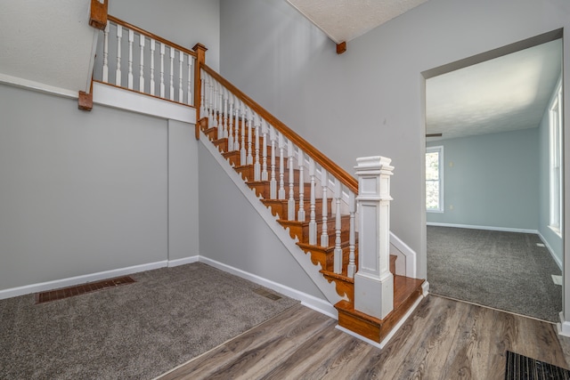 stairway featuring a textured ceiling and hardwood / wood-style floors