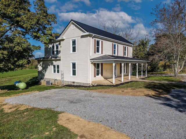 view of front of home featuring covered porch, cooling unit, and a front lawn