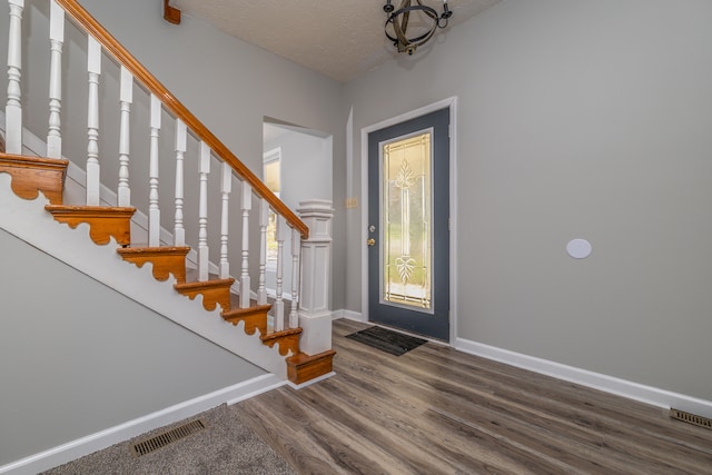 entrance foyer with a textured ceiling and wood-type flooring