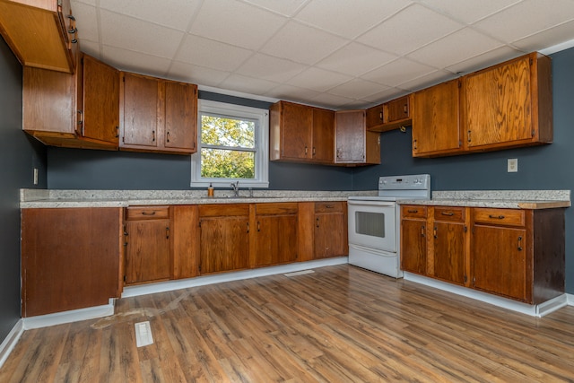 kitchen featuring sink, a drop ceiling, light wood-type flooring, and white electric stove