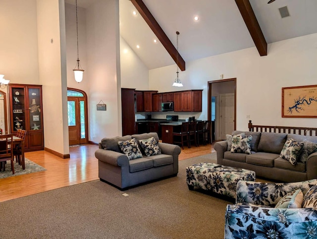 living room featuring beam ceiling, light hardwood / wood-style flooring, and high vaulted ceiling