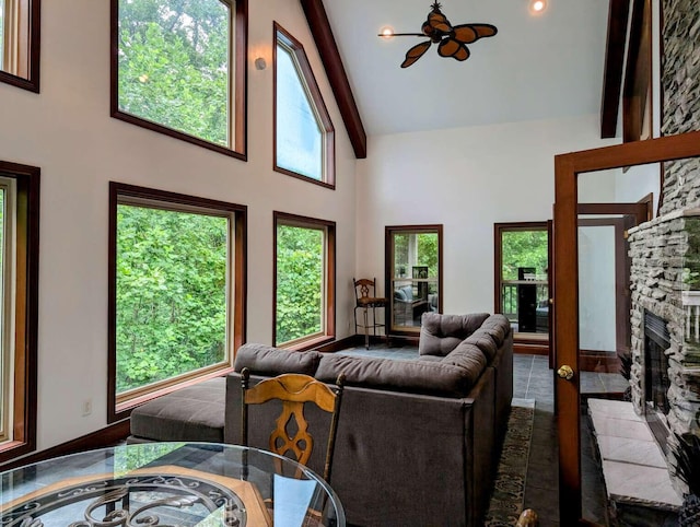 living room with beamed ceiling, a fireplace, and a wealth of natural light