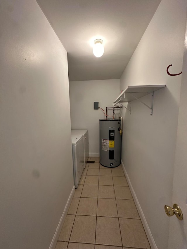 washroom featuring water heater, light tile patterned flooring, and washer and dryer