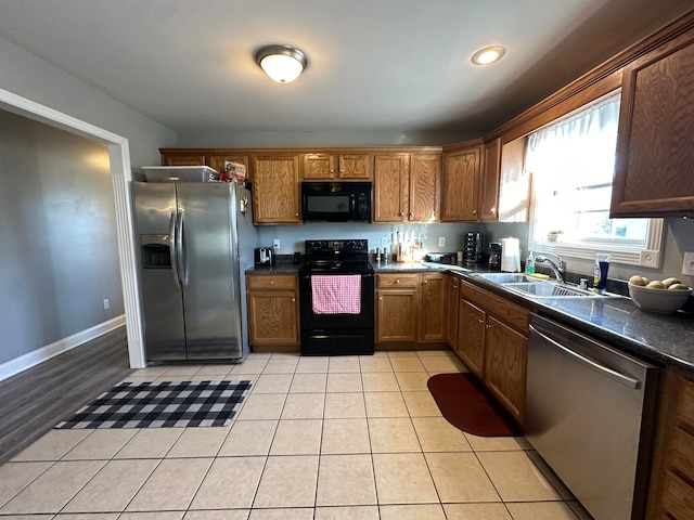 kitchen featuring black appliances, sink, and light tile patterned floors