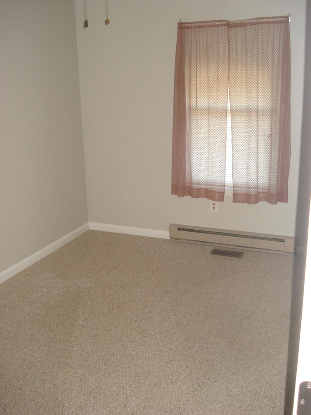 unfurnished room featuring carpet floors and baseboard heating