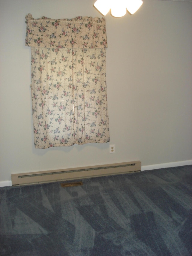 carpeted empty room with baseboard heating