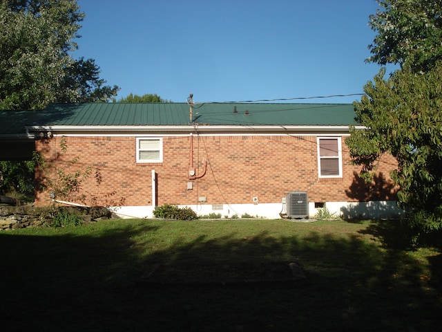 view of home's exterior featuring central air condition unit and a yard