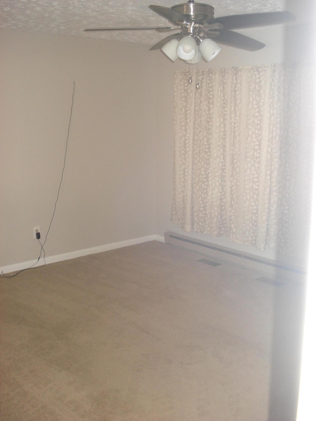 carpeted spare room with a textured ceiling and ceiling fan