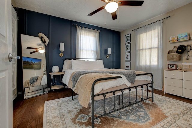 bedroom with multiple windows, a textured ceiling, hardwood / wood-style flooring, and ceiling fan