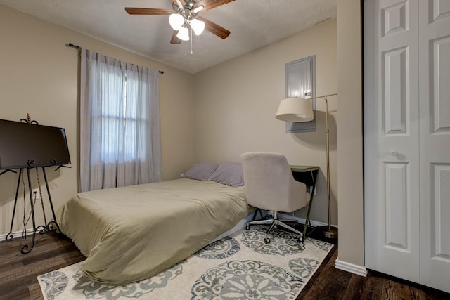 bedroom with a closet, a textured ceiling, dark wood-type flooring, and ceiling fan