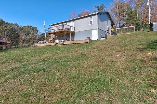 rear view of property featuring a wooden deck and a lawn