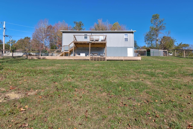 back of property featuring a wooden deck and a yard