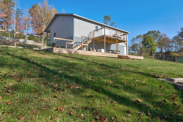 rear view of house featuring a deck and a yard